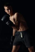 bokser leunde vooruit Aan zwart achtergrond met handschoenen bijgesneden visie foto