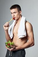 sportief Mens aan het eten salade gezond voedsel bodybuilder levensstijl foto