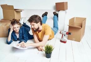 Mens en vrouw in de kamer Aan de verdieping vernieuwing werk in beweging en dozen van gereedschap foto