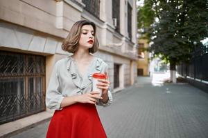 blond buitenshuis rood rok heet drinken buitenshuis in zomer foto