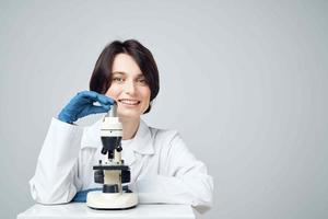 vrouw laboratorium assistent op zoek door een microscoop diagnostiek Onderzoek wetenschap foto