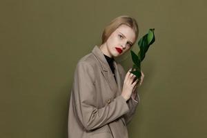 mooi vrouw in jas rood lippen mode palm blad geïsoleerd achtergrond foto