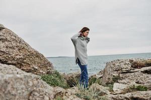 portret van een vrouw strand toerisme bewolkt weer steen kust ontspanning concept foto