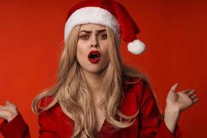 vrouw vervelend de kerstman hoed Kerstmis vakantie rood achtergrond foto