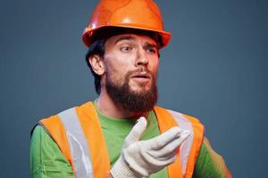 Mens in werk uniform oranje verf veiligheid werk vermoeidheid blauw achtergrond foto