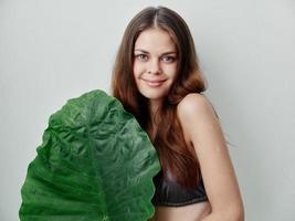 mooi vrouw in zwempak groen blad exotisch charme licht achtergrond foto