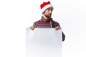 emotioneel Mens in een Kerstmis hoed met wit mockup poster Kerstmis geïsoleerd achtergrond foto