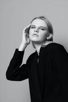 mode model- meisje poseren met haar handen omhoog in de studio in zwart en wit stijl in een klassiek jasje foto