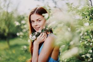 vrouw portret prachtig glimlachen met tanden voorjaar geluk in natuur tegen een groen boom hand- tintje tederheid, veiligheid van allergieën en insecten foto