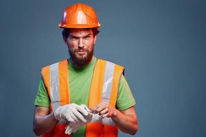 een Mens in een werk uniform is een bouw ingenieur. industrie professioneel oranje moeilijk hoed foto