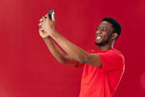 vrolijk Mens van Afrikaanse uiterlijk Holding telefoon bovenstaand zijn hoofd communicatie geïsoleerd achtergrond foto