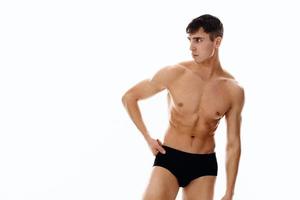 sexy atletisch Mens met gemotiveerd omhoog buikspieren in donker shorts geïsoleerd achtergrond foto