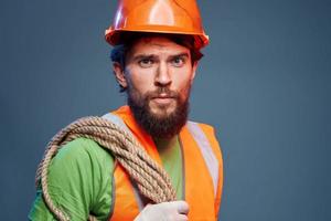 een werken Mens in een oranje verf touw in de handen van een bouw professioneel foto