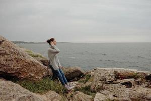 mooi vrouw vrijheid wandelen Aan de steen kust vrouw ontspannende foto