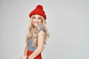 blond in modieus kleren rood hoed poseren studio foto