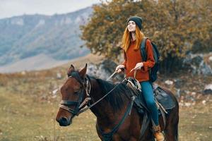 vrouw wandelaar ritten een paard Aan natuur in de bergen foto