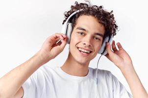 Mens met gekruld haar- en in hoofdtelefoons luistert naar muziek- foto