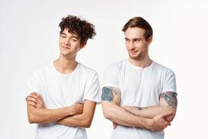 grappig twee mannen in wit t-shirts zijn staand kant door kant geïsoleerd achtergrond foto