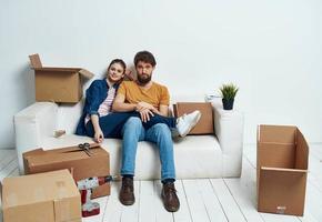 Mens en vrouw Aan de bankstel in beweging dozen vernieuwing werk vrije tijd interieur kamer foto