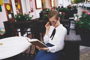 leerling met een boek in zijn handen buitenshuis in een zomer cafe rust uit communicatie foto
