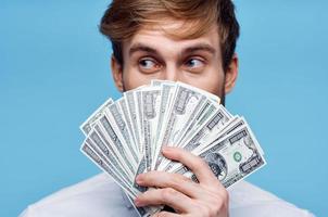 Mens Holding geld detailopname rijkdom succes blauw achtergrond foto