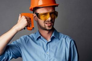 vrolijk Mens in oranje moeilijk hoed bouw professioneel gereedschap foto