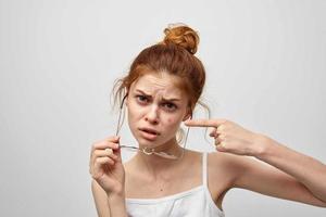 vrouw in een wit t-shirt met bril puistjes Aan haar gezicht foto