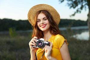 glimlachen vrouw met camera in handen natuur reizen levensstijl hobby foto