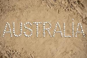 Australië - woord gemaakt met stenen Aan zand foto