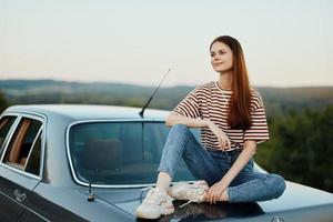 vrouw zittend in haar auto Aan een weg reis en ontspannend, levensstijl Aan de weg foto