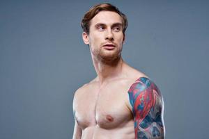 Mens met tatoeëren naakt torso sport geschiktheid grijs achtergrond portret foto