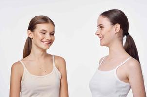 twee vriendinnetjes in wit t-shirts knuffels communicatie licht achtergrond foto