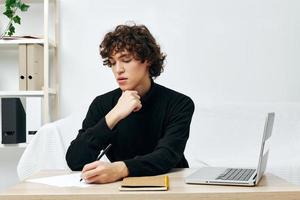 gekruld vent Aan een wit sofa in voorkant van een laptop aan het leren levensstijl technologie foto