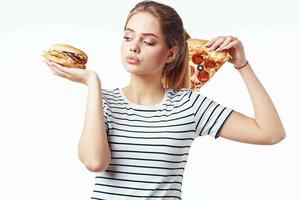 vrouw in gestreept t-shirt aan het eten pizza snel voedsel eetpatroon licht achtergrond foto