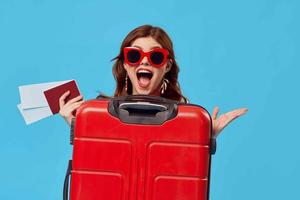 vrolijk vrouw toerist rood koffer passagier luchthaven vlucht documenten foto