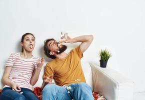 Mens en vrouw aan het kijken films binnenshuis met popcorn en bloem in een pot foto