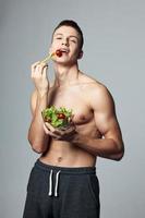 sport- Mens met een bord van salade energie groenten gezond voedsel foto