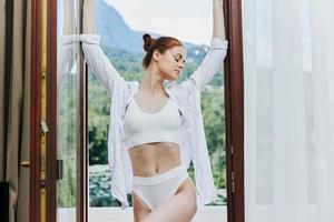slank vrouw in sexy lingerie poseren Aan balkon levensstijl foto