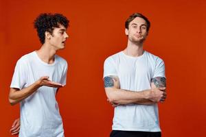 mannen in wit t-shirts communicatie vriendschap rood achtergrond foto