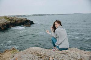 mooi vrouw strand toerisme bewolkt weer steen kust ontspanning concept foto