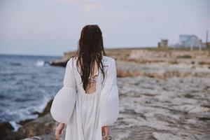 vrouw door de oceaan stenen wandelen terug visie foto