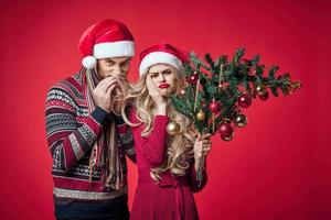 jong paar vieren Kerstmis samen decoratie rood achtergrond foto