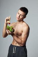 atletisch Mens met een gemotiveerd lichaam bord salade groenten gezond voedsel levensstijl foto