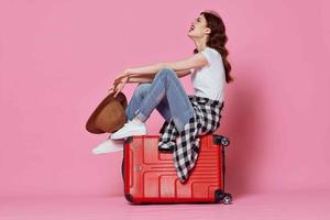 vrolijk vrouw met rood koffer reizen roze achtergrond vlucht foto