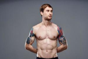 sport Mens bijgesneden visie training tatoeëren Aan armen grijs achtergrond foto