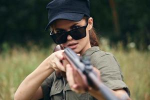 vrouw soldaat het richten jachtgeweer zonnebril detailopname vers lucht groen bomen foto