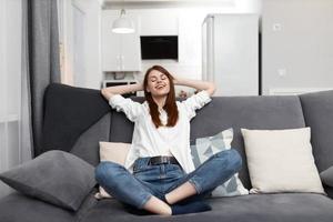 vrouw met Gesloten ogen zittend Aan de bankstel gooide terug haar hoofd Bij huis foto