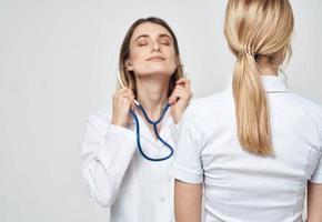 verpleegster in medisch japon stethoscoop en geduldig terug visie foto