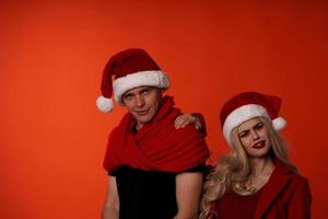 Mens en vrouw in nieuw jaar kleren Kerstmis vakantie rood achtergrond foto