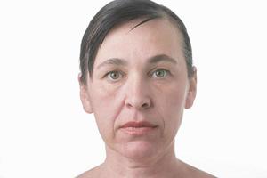 de gezicht van een vrouw met rimpels. portret van een ouderen vrouw zonder behandeling Aan een wit achtergrond foto